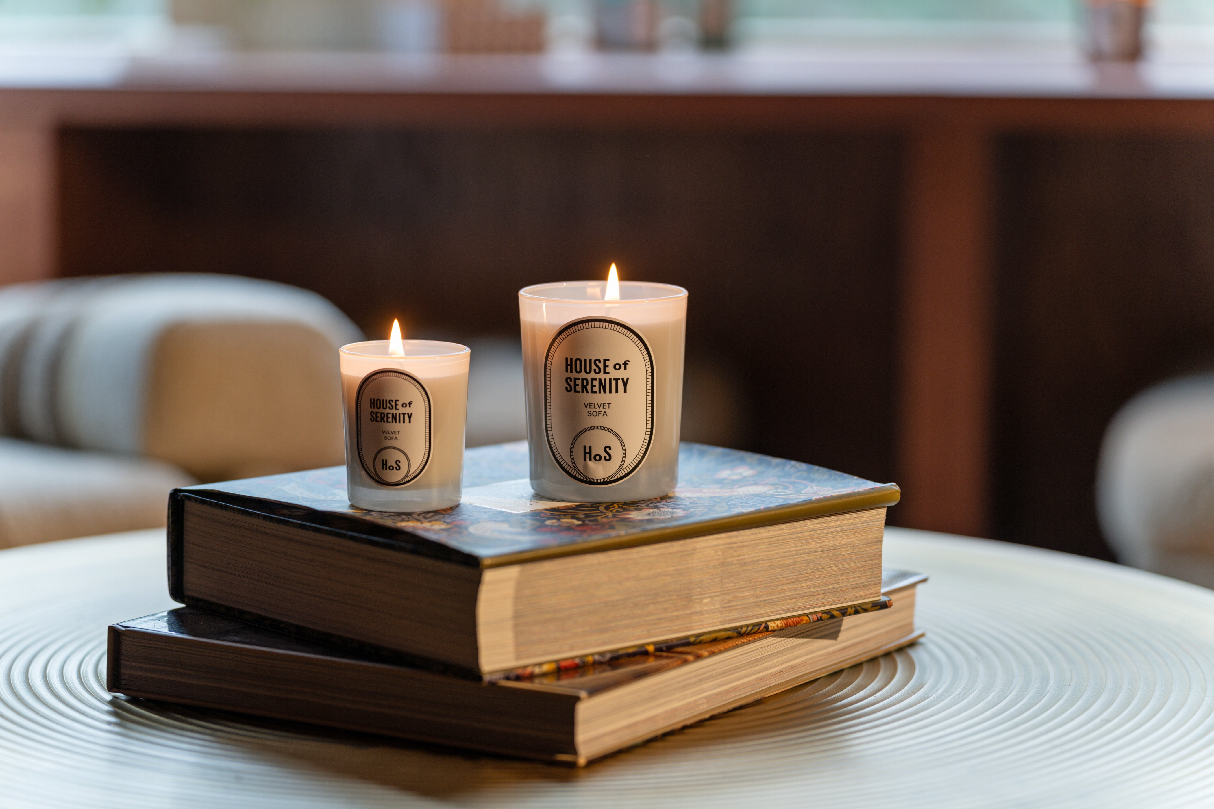Deux bougies allumées sur des livres diffusent une ambiance apaisante et chaleureuse